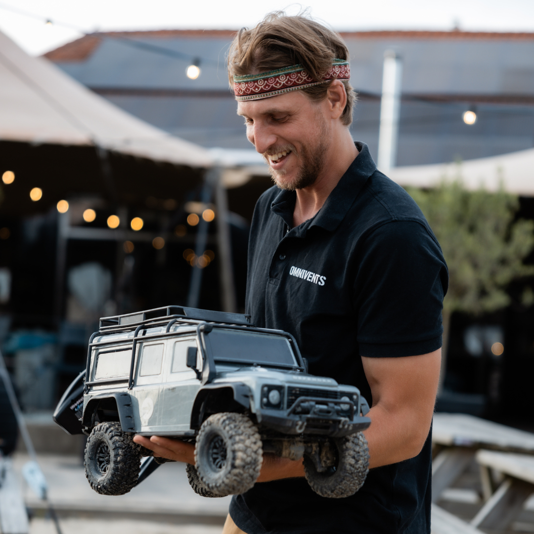 Netwerkbijeenkomst case man die miniatuur Landorver defender vastheeft