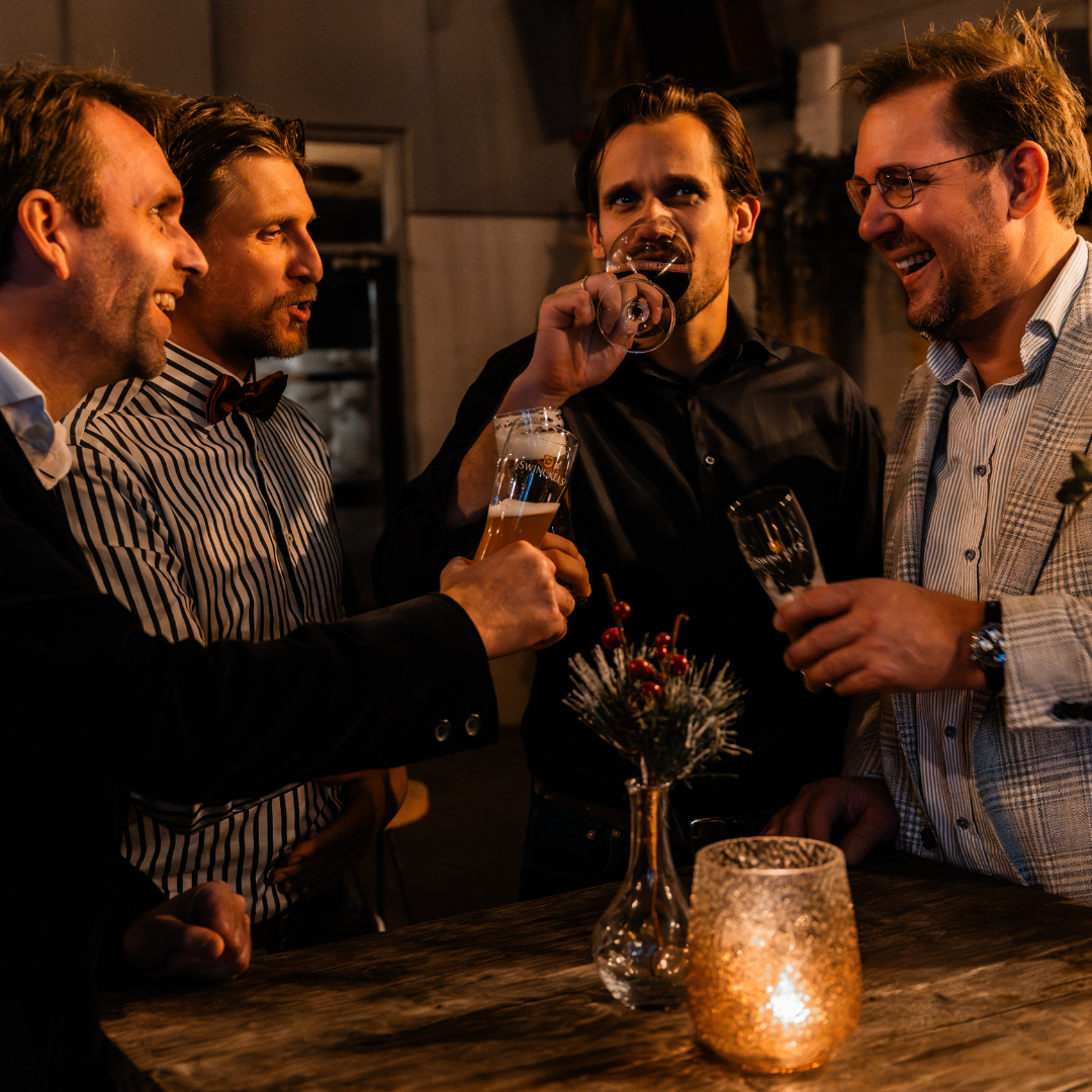 Relatiedag groep mannen doen een drankje aan een statafel
